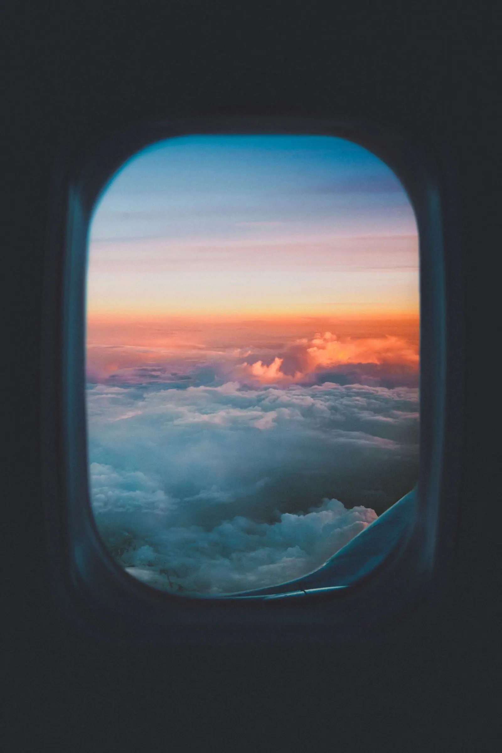 Sunset above the clouds through an aircraft window